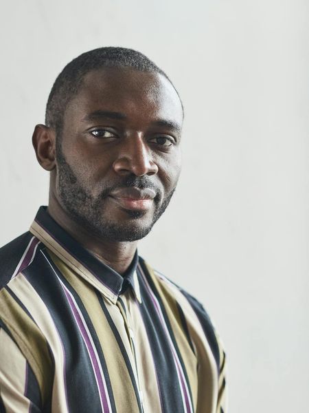 Man in a calm, focused pose against a sandy background.